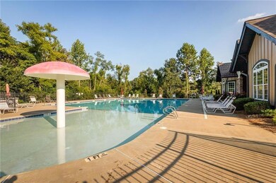 Community pool featuring a patio and view of wooded area