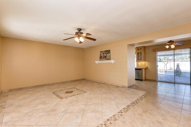Living Room with tile floors open to the dining room with access to covered patio area!