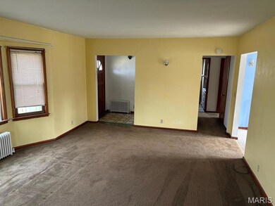 Carpeted empty room featuring radiator heating unit