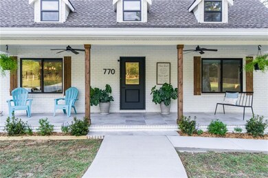 Entrance to property featuring covered porch and r