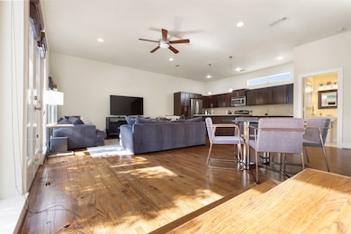Dining area with dark wood-style floors, a ceiling fan, and recessed lighting
