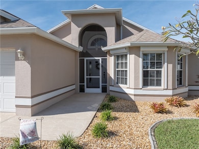 View of exterior entry with a sunroom, stucco siding, a garage, and roof with shingles