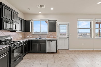 Kitchen with light tile patterned floors, a sink,