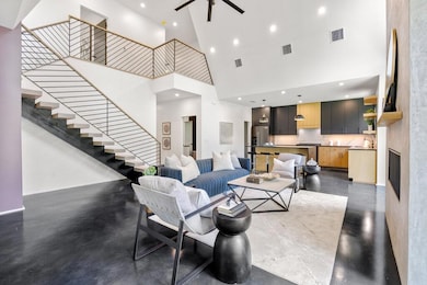 Living room with a towering ceiling, stairs, rece