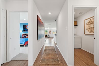 Corridor featuring wood finished floors, visible v