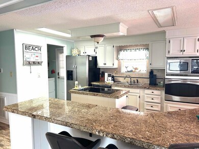 Kitchen featuring stainless steel appliances, a kitchen island,  and a kitchen breakfast bar