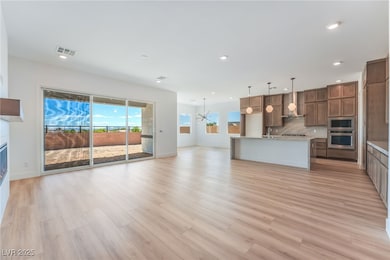 Kitchen featuring open floor plan, decorative light fixtures, decorative backsplash, a center island with sink, and appliances with stainless steel finishes