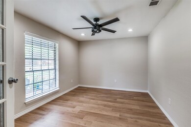 Enclosed office featuring ceiling fan and light ha