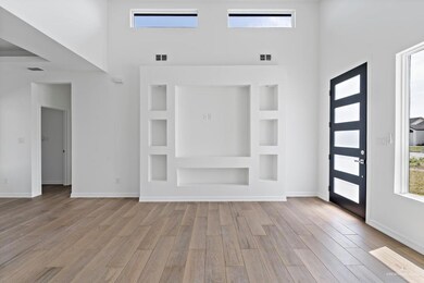 Foyer entrance featuring light hardwood / wood-style flooring and a high ceiling