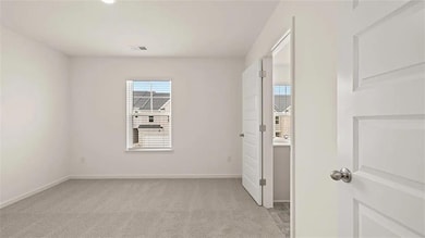 Empty room with light carpet and baseboards