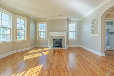 Living room featuring a tiled fireplace, light har
