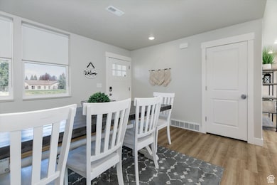 Dining space with light wood finished floors, plenty of natural light, and recessed lighting