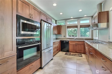 Kitchen view 1 from entry. Love the higher-end appliances, large tile flooring, solid surface counter and custom cabinetry with DRAWERS! I need more drawers in my kitchen!!
