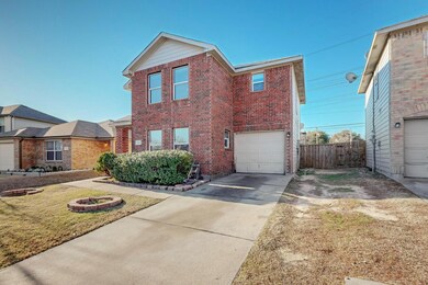 View of front of house with a fire pit, a garage, 