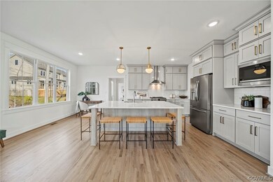 Kitchen with wall chimney exhaust hood, light hard