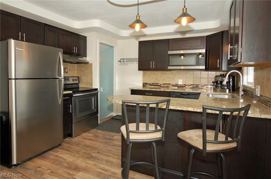 Kitchen with wood-style flooring, stainless steel appliances, and backsplash