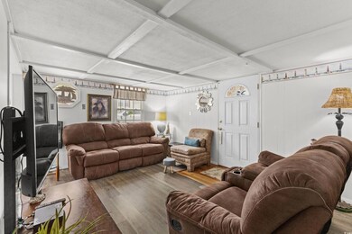 Living room with wood finished floors, coffered ceiling, and beamed ceiling