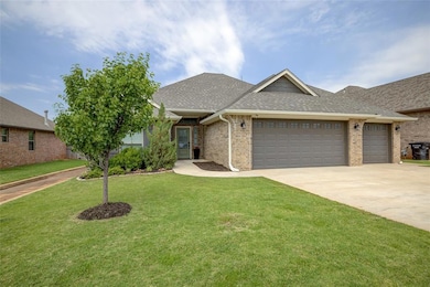 View of front of house with roof with shingles, a garage, and brick siding
