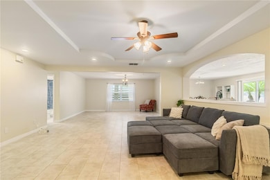 Living room with tray ceiling and a ceiling fan