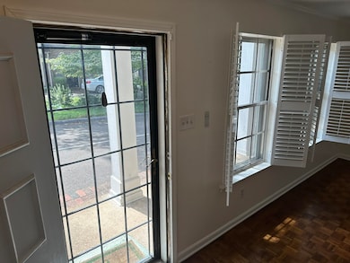 Doorway to outside with dark parquet flooring