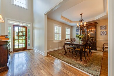 Formal dining room view from foyer with trey ceiling, soft dimmer switch lighting, chair rail comfortably seats six to eight guests. 
