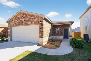 View of front of property with brick siding, stone siding, an attached garage, and driveway