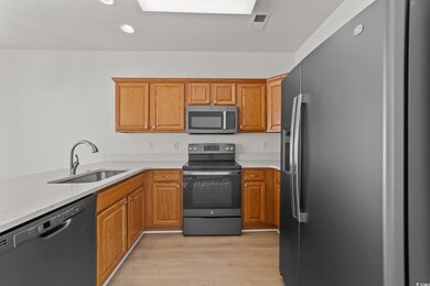 Kitchen with sink, light stone counters, kitchen p