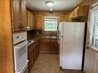 Kitchen featuring white appliances and sink