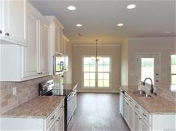Kitchen has granite countertops, stainless steel a