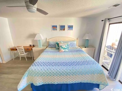 Bedroom featuring a textured ceiling, light hardwo
