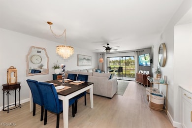 Dining room featuring light wood-style floors, a ceiling fan, and a chandelier