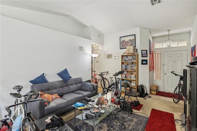 Living room featuring visible vents and lofted cei