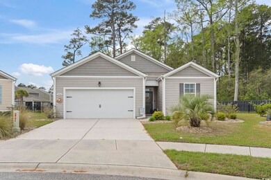 View of front of property with a front yard, driveway, fence, and an attached garage