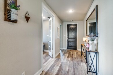Entryway featuring baseboards and light wood finis