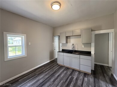Kitchen featuring dark countertops, dark wood-style floors, and gray cabinets