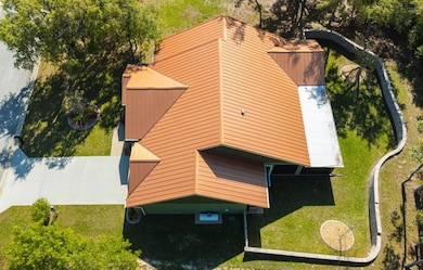 Gorgeous copper coloured metal roof. Stone fence / retaining wall. Landscaping. Large driveway.