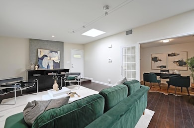 Living room with wood finished floors, a skylight