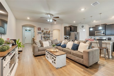 Living room featuring arched walkways, ceiling fan