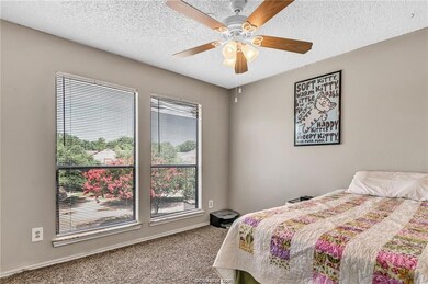 Bedroom featuring carpet flooring, a textured ceiling, and ceiling fan
