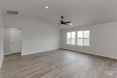 Spare room with light wood-style floors, vaulted ceiling, recessed lighting, and ceiling fan