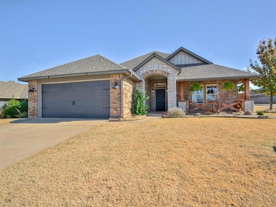 View of front of house featuring a shingled roof, brick siding, concrete driveway, a front yard, and covered porch