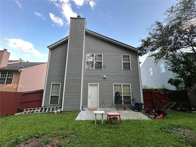 Rear view of property featuring a fenced backyard, a patio, and a chimney