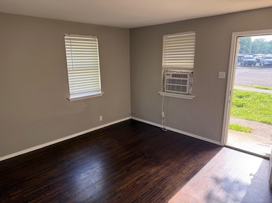 Spare room with dark wood-style floors, baseboards, and cooling unit