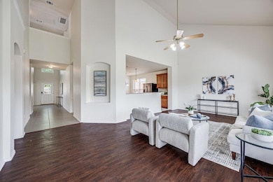 Living area with wood finished floors, high vault