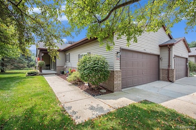 View of front of property with a front lawn, concrete driveway, and brick siding
