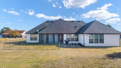 Back of property with a yard and a patio