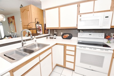 Kitchen with light tile patterned flooring, backsp