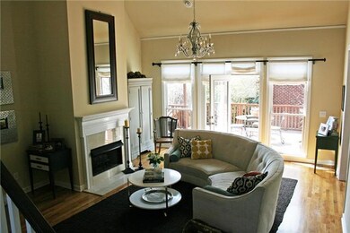 Light-filled great room with fireplace, opens to deck