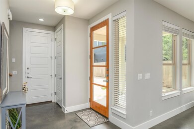 Foyer featuring baseboards, concrete floors, plen