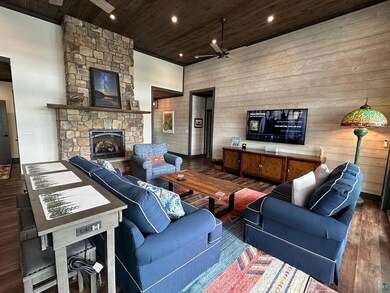 Living room featuring wooden ceiling, ceiling fan,